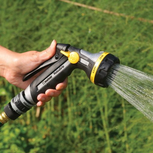 Melnor RelaxGrip Nozzle spraying water with a shower spray pattern in front of greenery