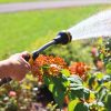 Melnor RelaxGrip® 8-Pattern 15” Watering Wand gently watering in front of flowers and a green lawn