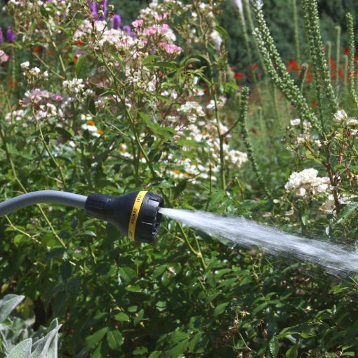 Melnor RelaxGrip 8-Pattern Watering Wand watering with the flat spray pattern in front of blooming flowers