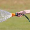 XT509 Melnor Fireman's Nozzle spraying in front of green grass background