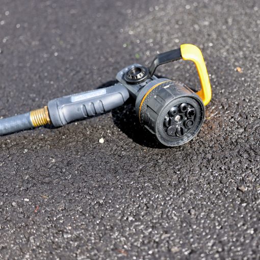 Melnor Torrent Hose Nozzle laying on asphalt driveway