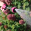 Raspberry Red Sprout Watering Wand spraying a flat spray in front of flowers