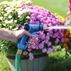 A person's hand holds a blue garden hose nozzle, labeled 