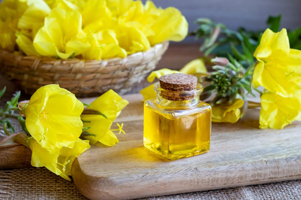 jar of Evening Primrose oil sitting in front of Evening Primrose blooms