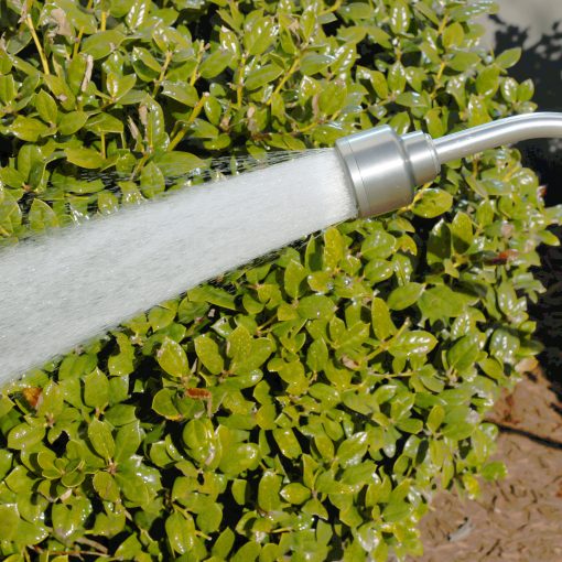 Melnor GentleRain Watering Wand gently spraying water in front of green shrubs