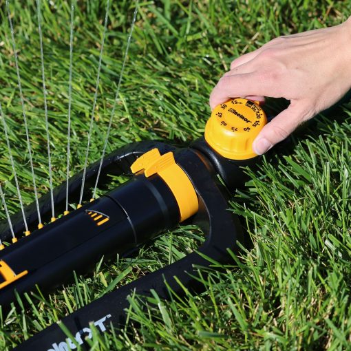 Hand setting timer on the Melnor XT Turbo Oscillating Sprinkler while gently watering