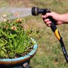 Melnor XT Fusion garden hose connected to a Melnor hose nozzle spraying potted flowers