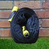 Melnor Heavy-Duty 50 Ft. Fabric Garden Hose rolled up leaning against a brick wall